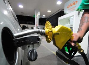 1_bico_de_bomba_de_gasolina_abastecendo_o_tanque_de_um_carro_prata_em_posto_de_combustivel-34747027